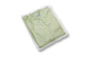 A clear package with a green dress shirt inside